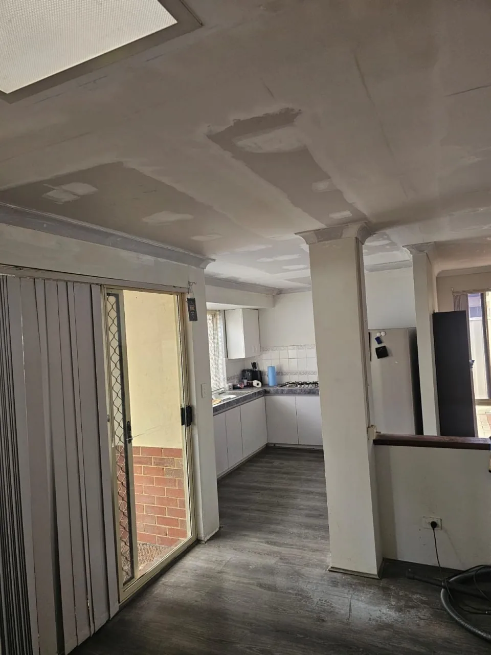 A Bassendean kitchen and dining ceiling with every join and screw line flushed in grey setting compound, waiting on paint
