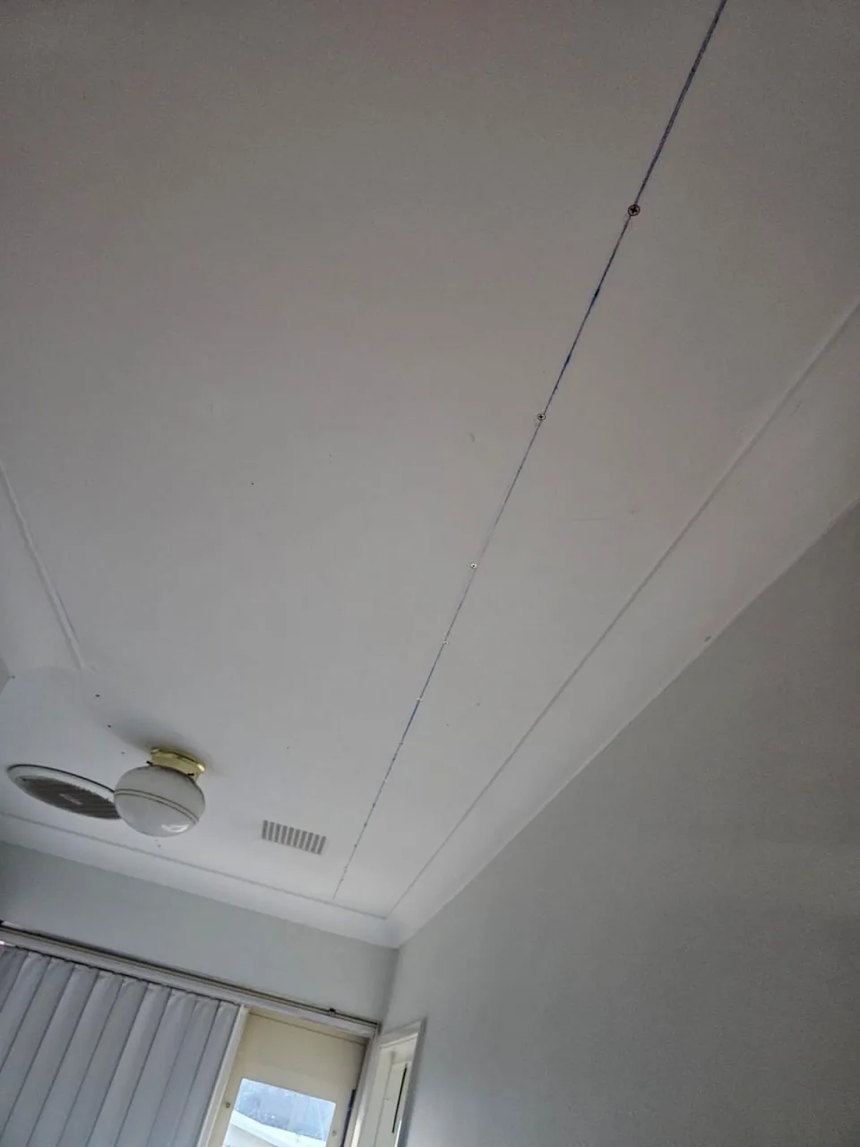 Bedroom ceiling in a Bassendean home with a blue chalk line snapped along the run of a joist and new screws driven in at intervals along it