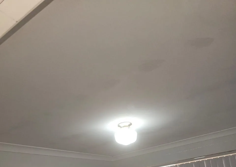 Bedroom ceiling in a Bassendean home showing brown water staining spreading across the plasterboard around the light fitting