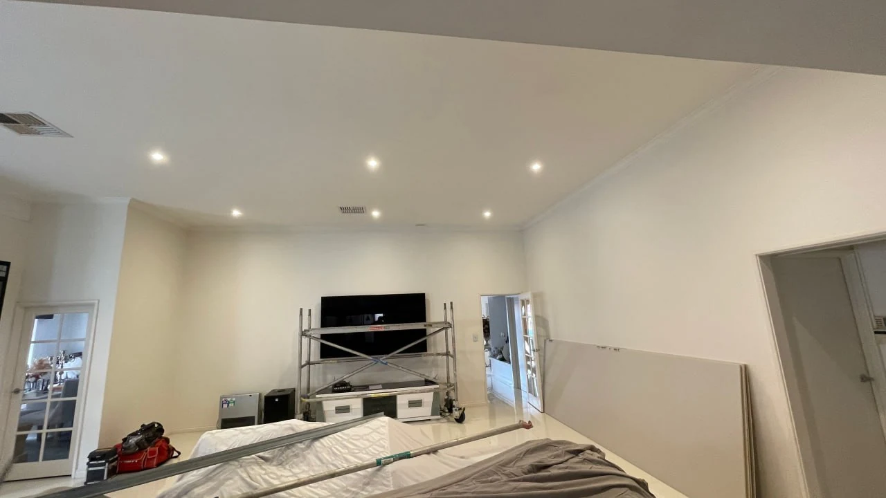 New Gyprock ceiling installed in a Perth home, sheets stacked against the wall and scaffold still up