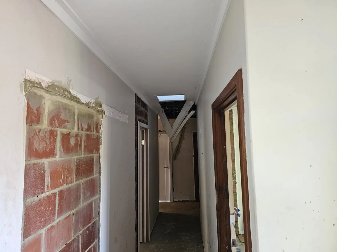 A Roleystone hallway with a new ceiling and cornice above an exposed brick feature wall that was kept through the renovation