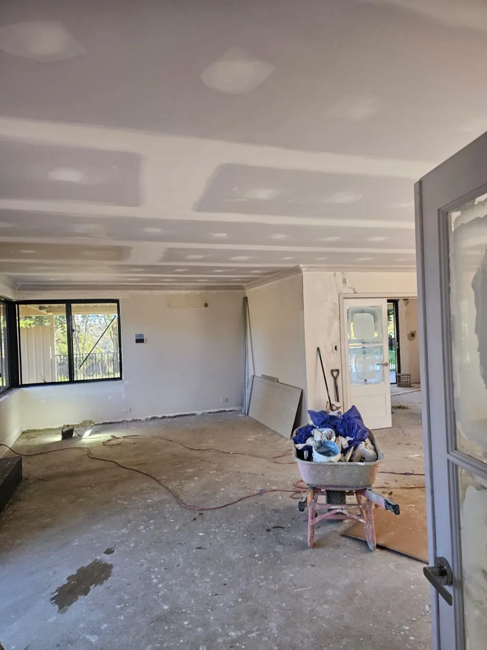 A new flat ceiling set across the open-plan living area of a Roleystone house, the floor still bare and tools in the room
