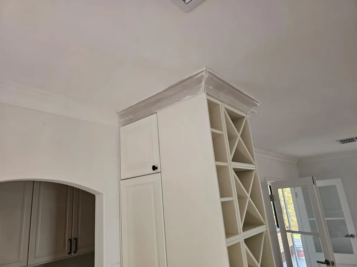 The new ceiling of a Roleystone house running through to the arched opening, with tall shelved joinery alongside